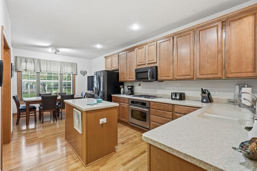 Open kitchen featuring center island, hardwood floors, and connection to dining area.