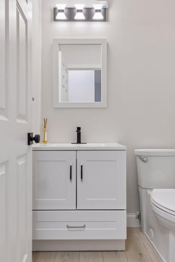 The updated main-floor powder room features a brand-new vanity and toilet for a fresh and modern look.
