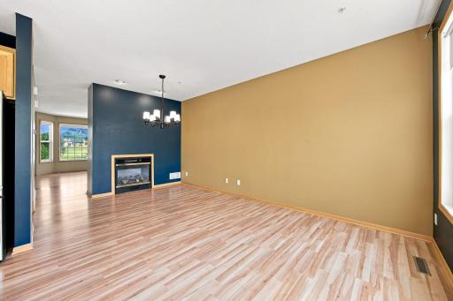 Double sided gas burning fireplace joins the living room and dining area.