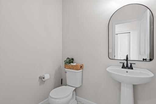 Main floor 1/2 bath located right off the kitchen - sellers updated the mirror and fixtures