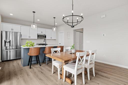 The kitchen features stainless steel appliances, quartz countertops, tile backsplash and a large pantry