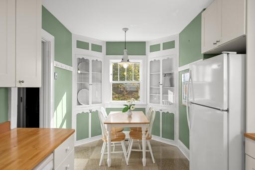 Bright and cheery eat-in kitchen with adorable built-in cabinets