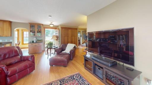 Spacious living room with warm hardwood floors and an open layout that flows easily into the kitchen and dining areas.