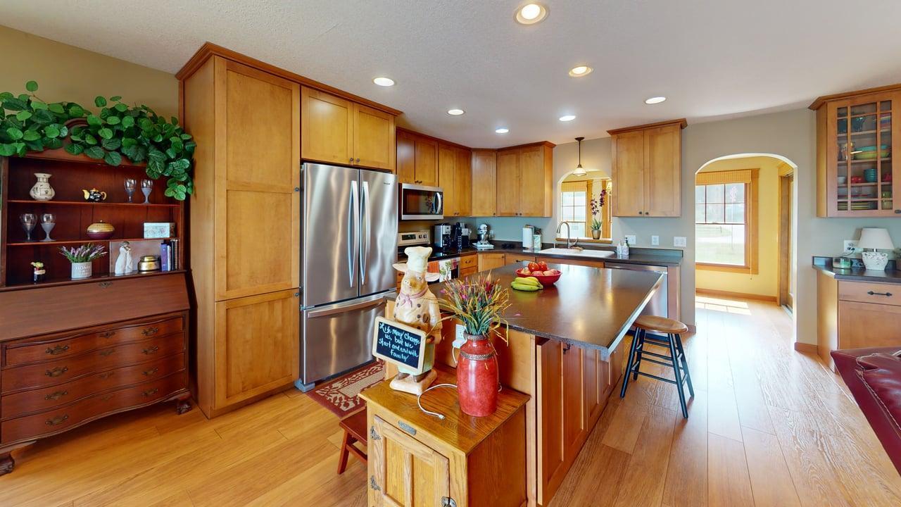 Spacious kitchen featuring warm wood cabinetry, stainless steel appliances and a large center island with plenty of room for casual seating.