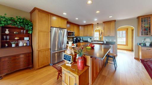 Spacious kitchen featuring warm wood cabinetry, stainless steel appliances and a large center island with plenty of room for casual seating.