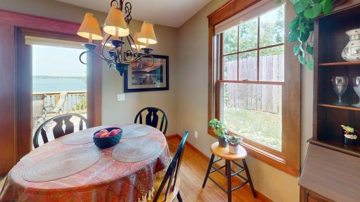 Informal dining room filled with natural light and lake views, offering a comfortable spot to gather with access to the lakeside deck.