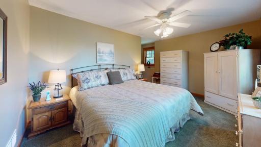 Spacious main-level primary bedroom offers a comfortable retreat with ceiling fan and plenty of room for additional furnishings.