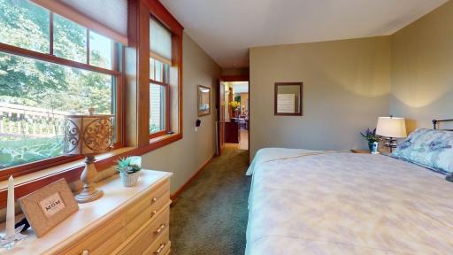 Large windows fill the main level primary bedroom with natural light while offering peaceful views of the surrounding property.