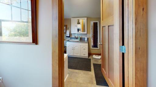 Upper-level three-quarter bathroom offers a convenient vanity area, mission-style doors, tiled flooring and plenty of natural light.