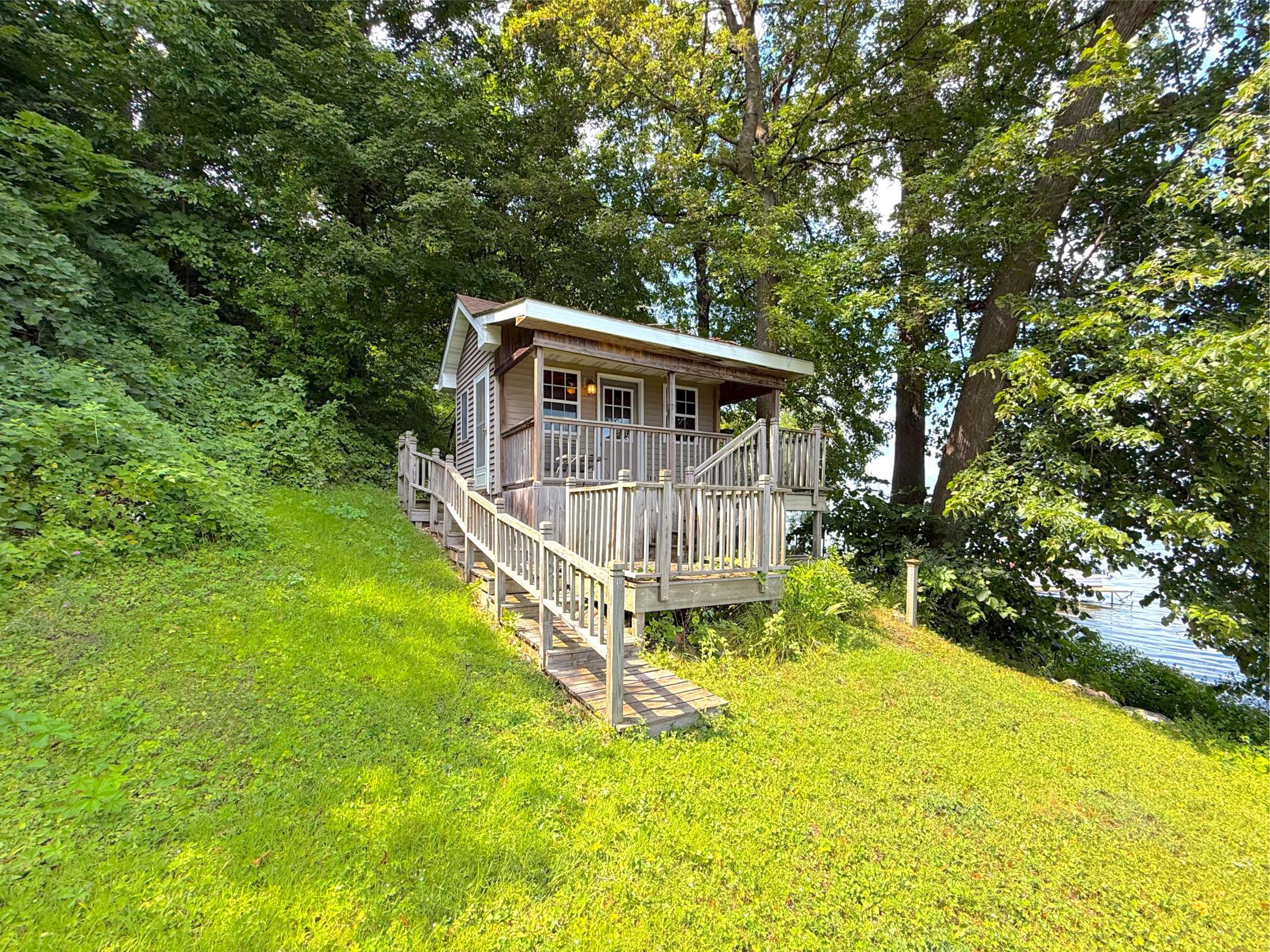 Charming lakeside shore-house tucked among mature trees, featuring multiple decks and wonderful lake views just steps from the water.