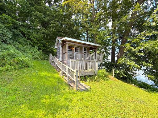 Charming lakeside shore-house tucked among mature trees, featuring multiple decks and wonderful lake views just steps from the water.