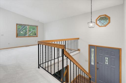 View from top of stairs across the main level living room. Interior has just been freshly painted