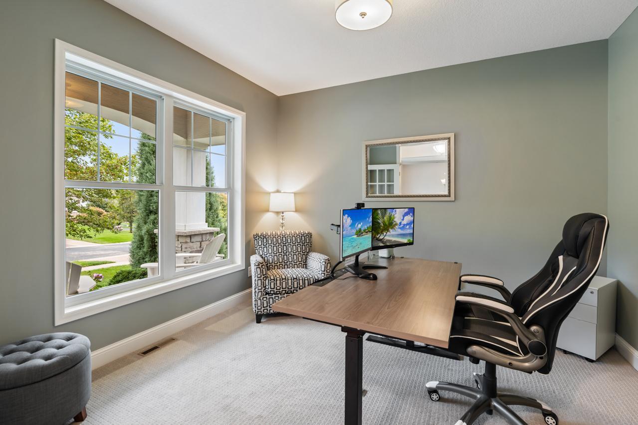 Comfortable main floor office featuring serene views of the front porch.