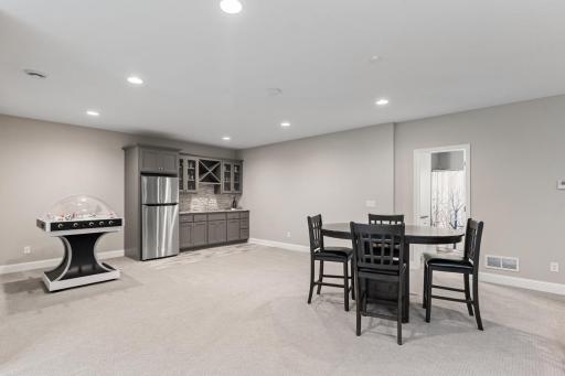 Built-in wet bar featuring ample storage and a convenient refrigerator.
