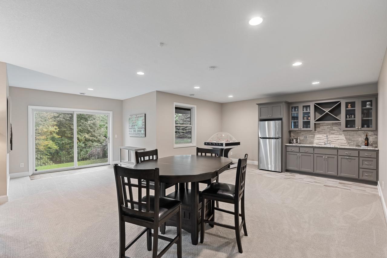 Open lower-level great room offering flexible use as a dining area or game room, with walkout access to the private backyard.