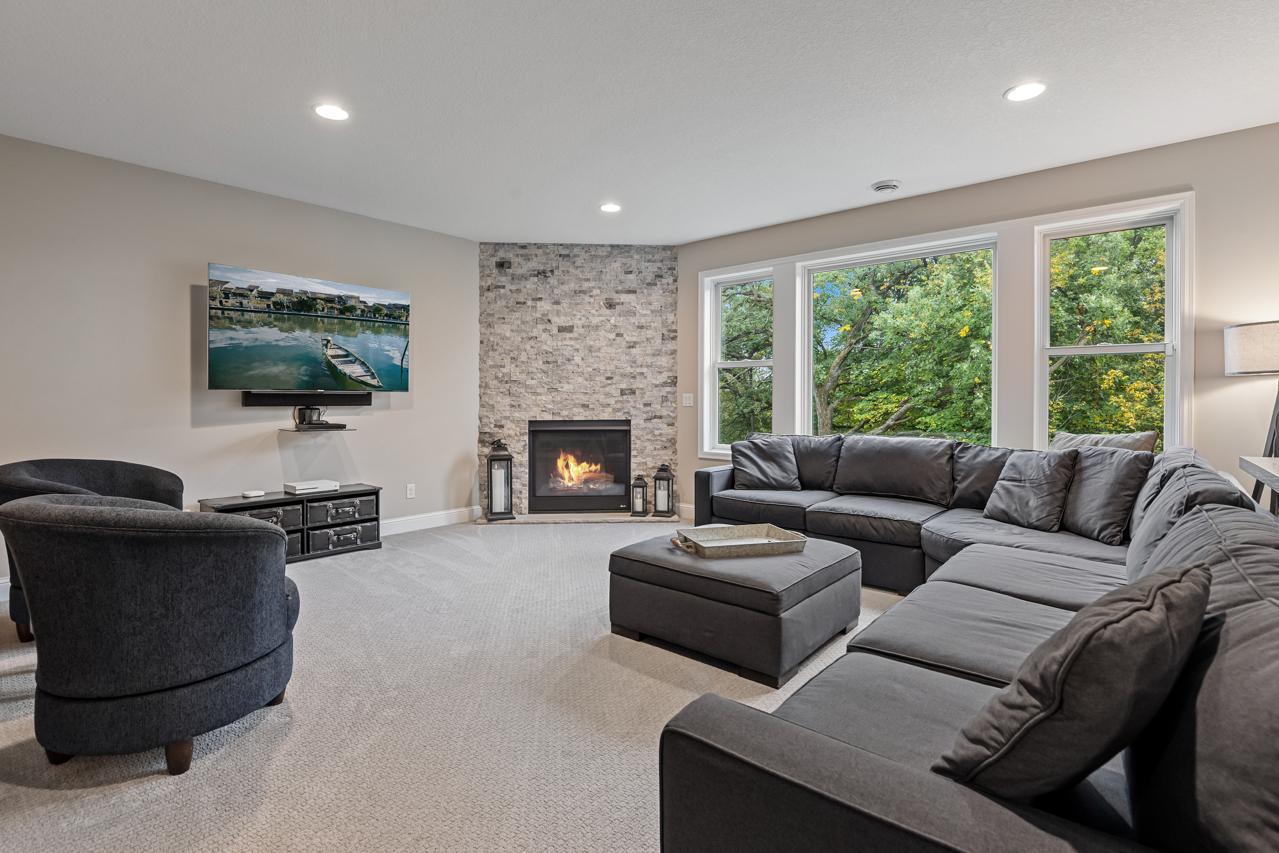 Spacious lower-level family room with a cozy gas fireplace and expansive backyard-facing windows.