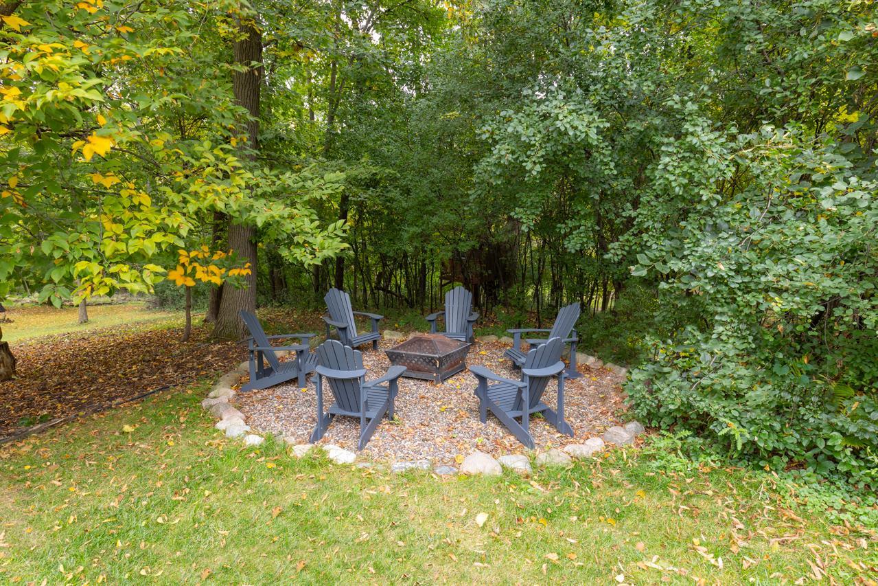 The backyard features a cozy fire pit perfect for relaxing evenings outdoors.