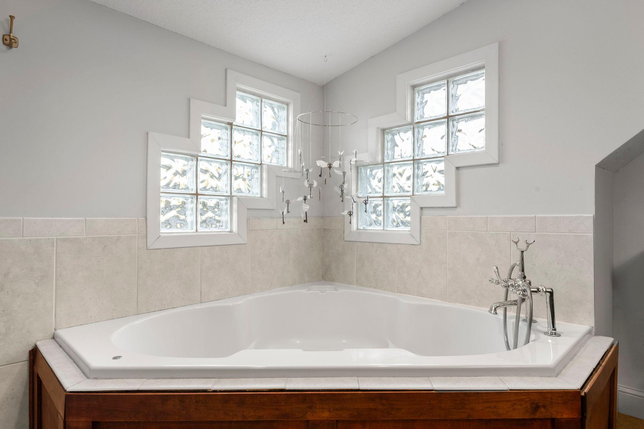 Corner jetted tub with glass block windows for privacy