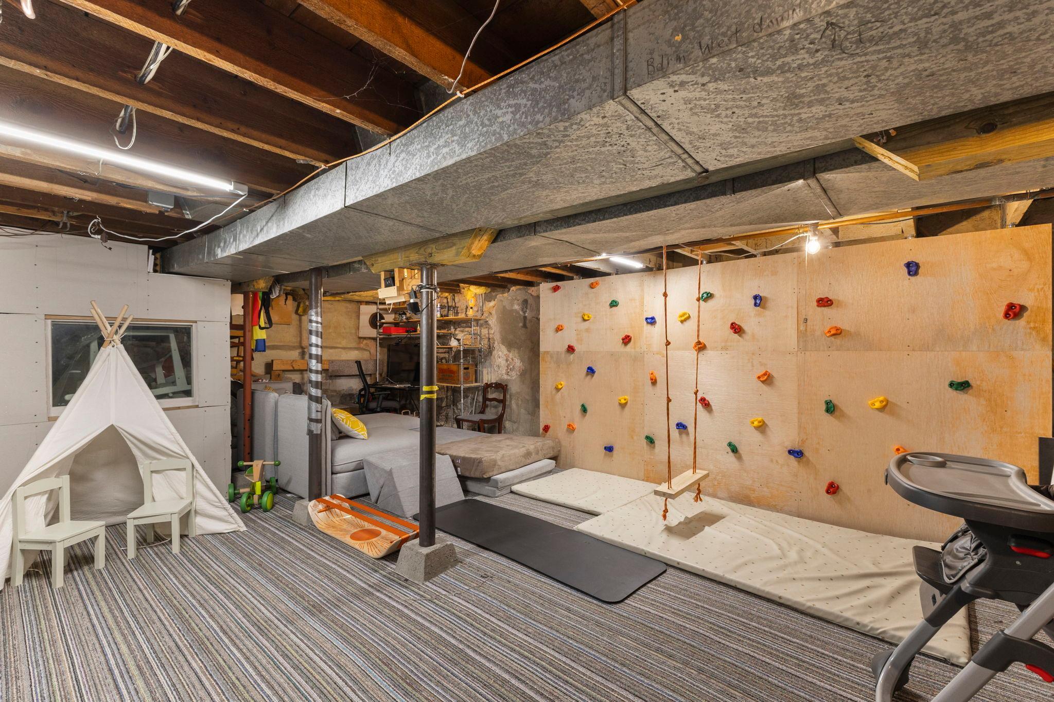 Lower level features a play area with rock climbing wall for kids