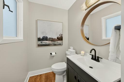 Main floor half bath with new vanity, lighting and hardwood floors.