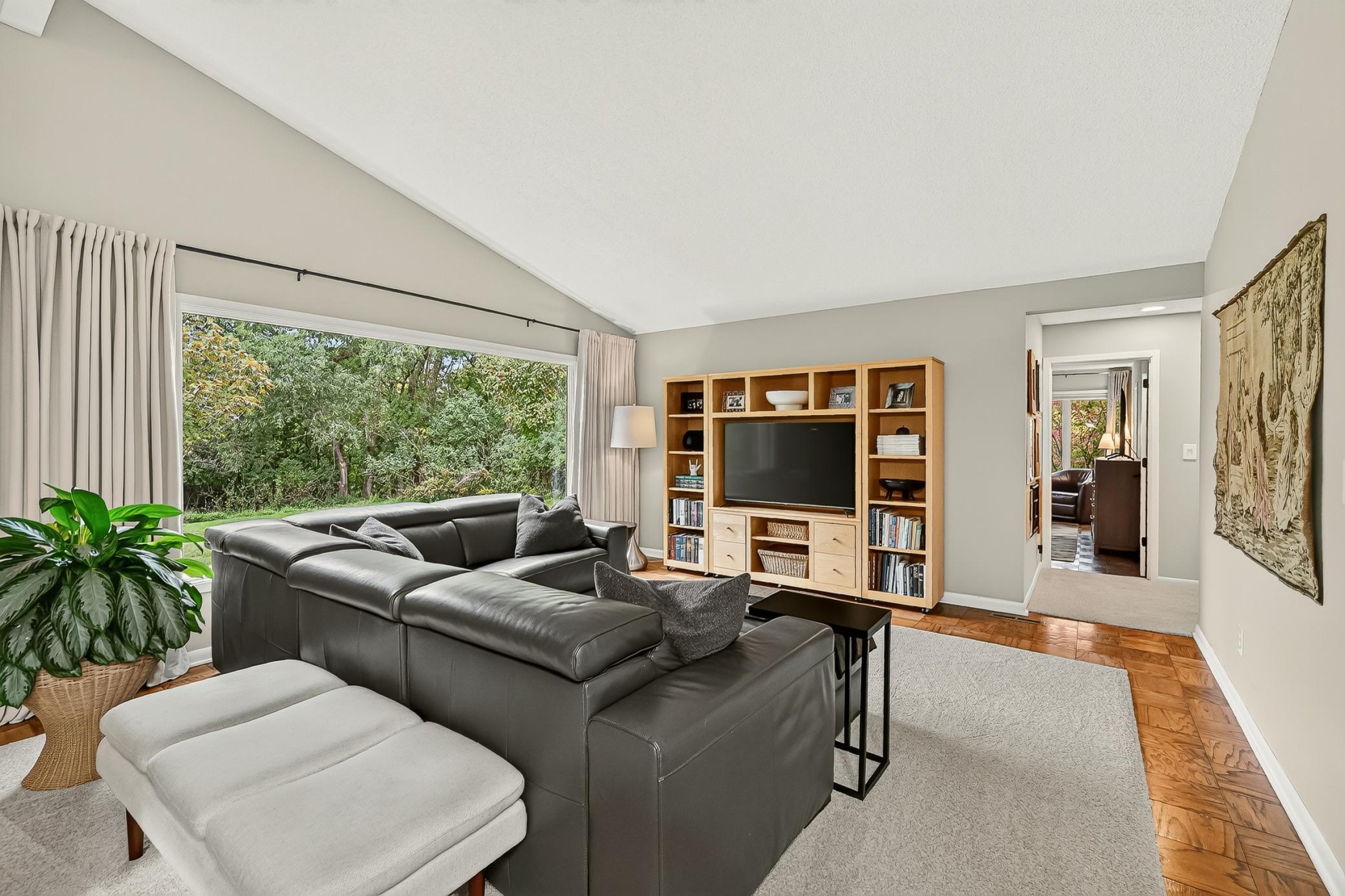 Flow into the second expansive living room space accented by the full wall window and then into the bedroom wing.