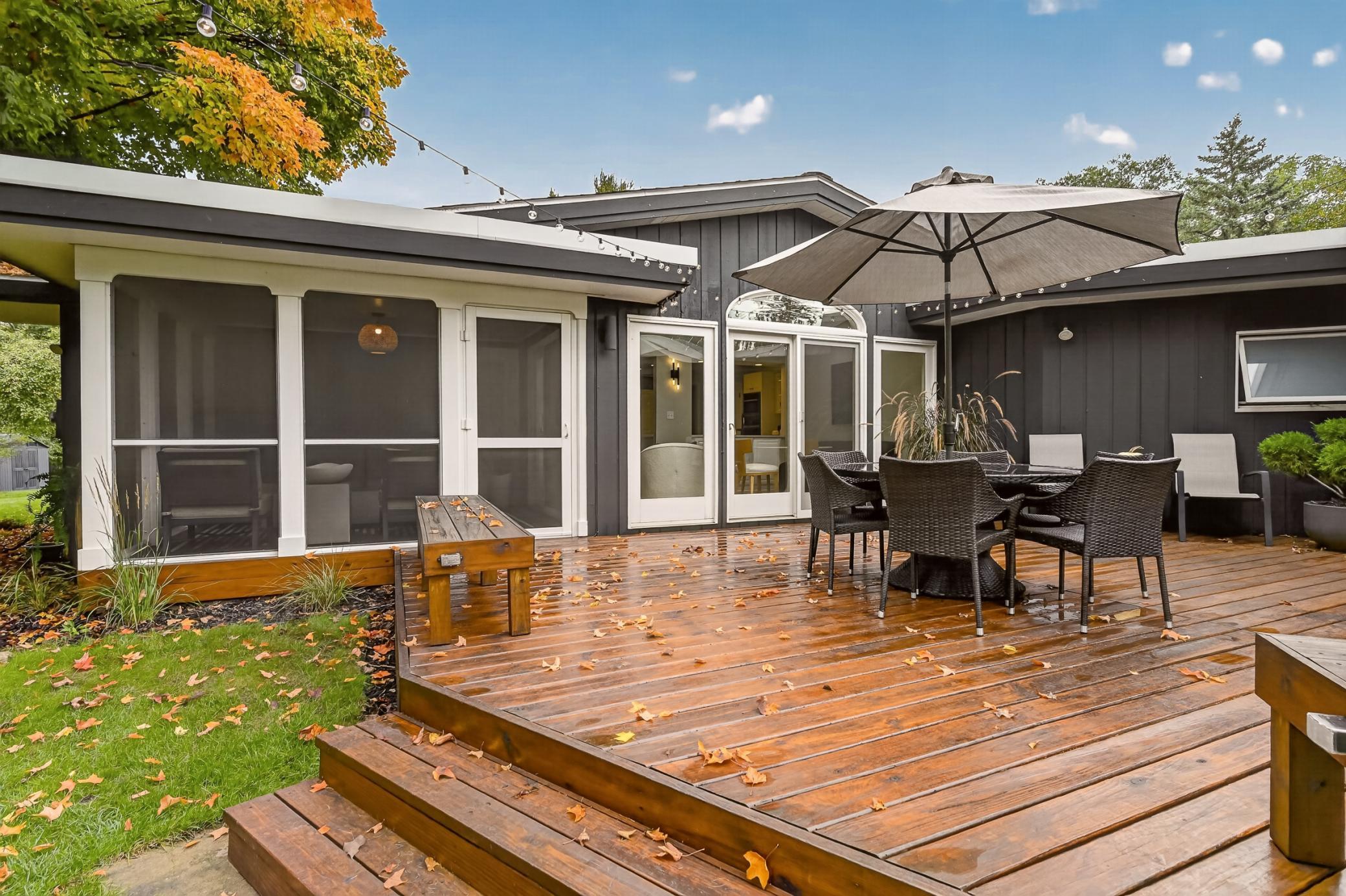 Twinkle lights surround the deck, creating a warm and inviting space to linger outdoors well into the evening, while the screened porch offers another perfect spot to relax while still taking in the outdoor air.