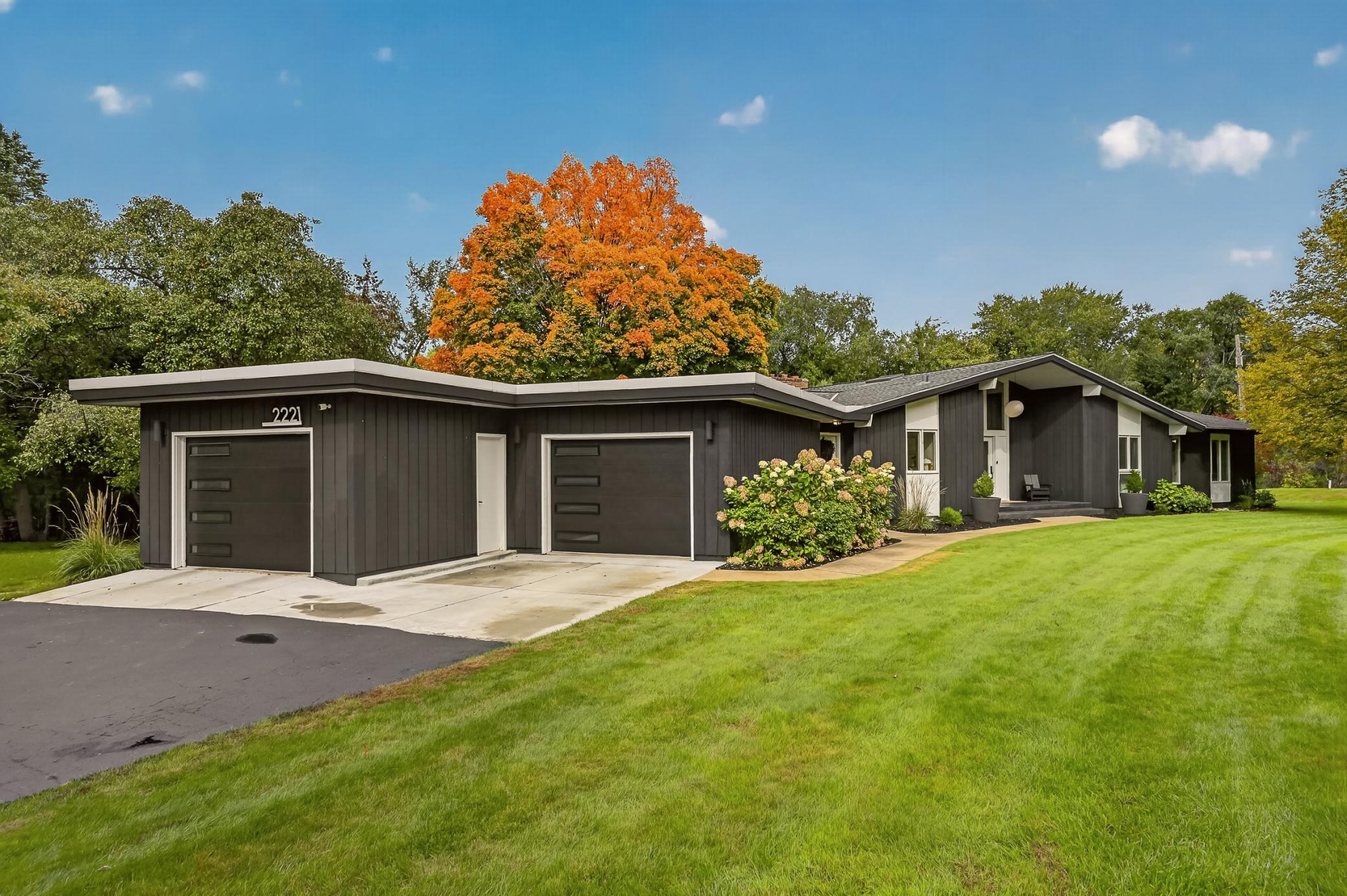 The home’s beautiful architectural angles are on full display here, tucked seamlessly into its natural surroundings. New garage doors complement the home’s distinctive mid-century modern design.