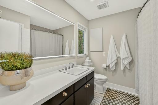 Light-filled full private ensuite with an expansive vanity, statement illuminated mirror and minimalist modern feel.