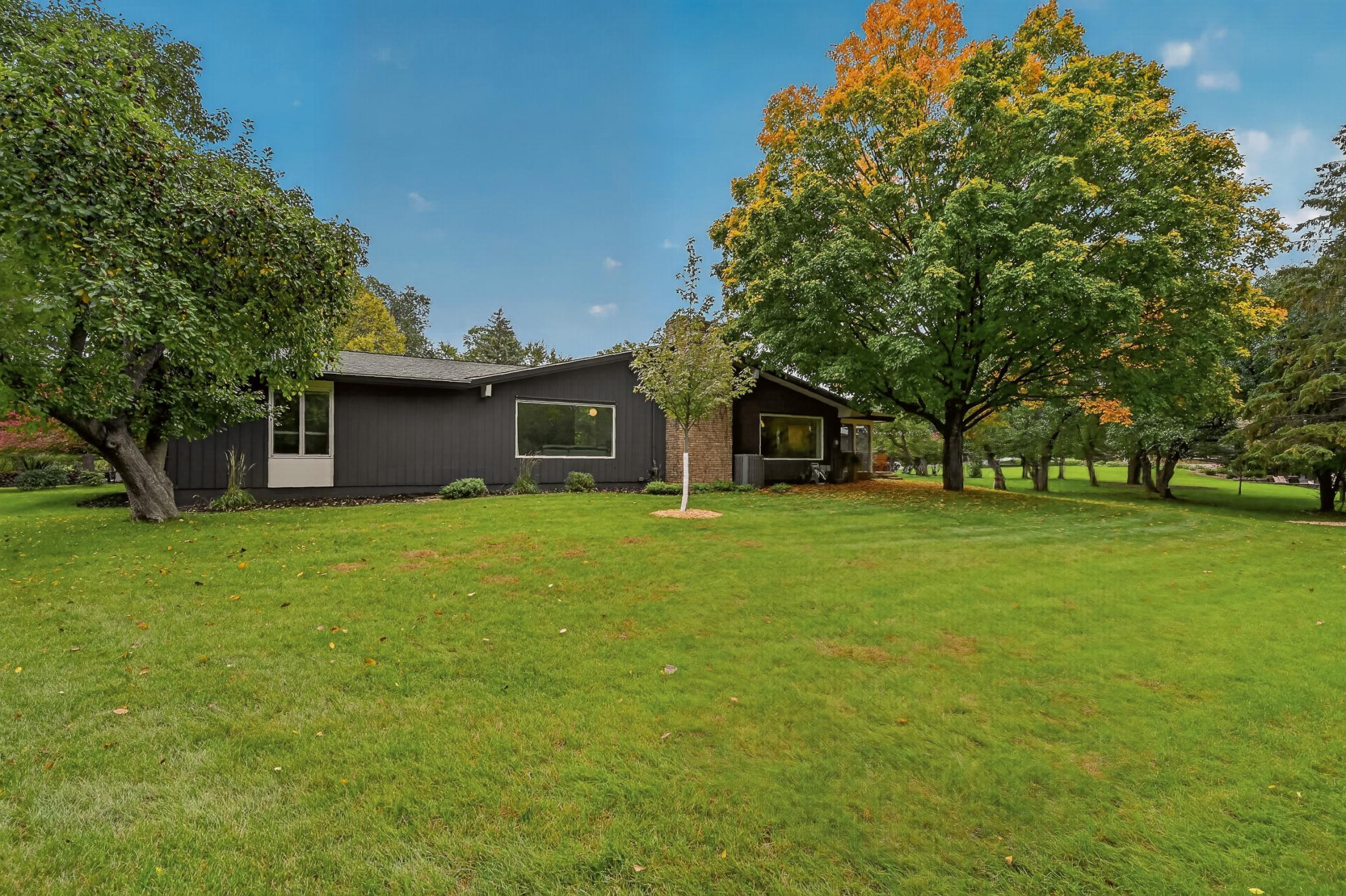 Another view of the expansive, level and usable lawn surrounding the home, offering beautiful outdoor space on every side.