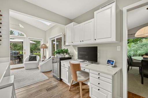 Desk area with beverage fridge and view to covered patio and deck.