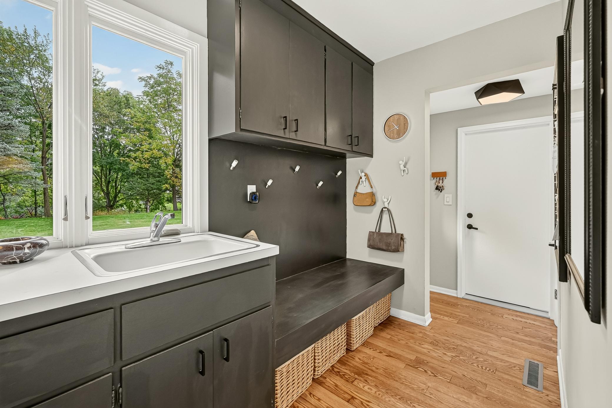 Mudroom featuring hardwood floors and storage bench.