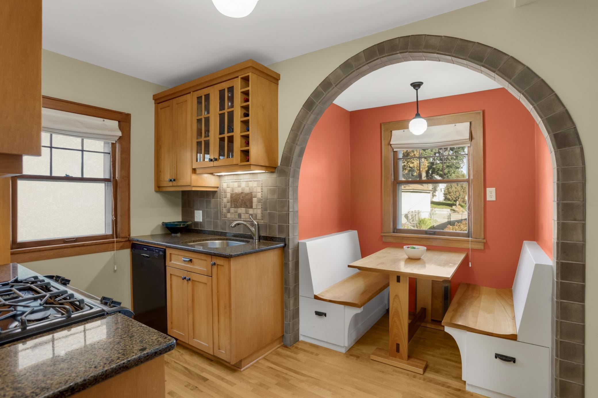 This beautifully updated kitchen features a gorgeous built-in breakfast nook framed under a beautiful archway
