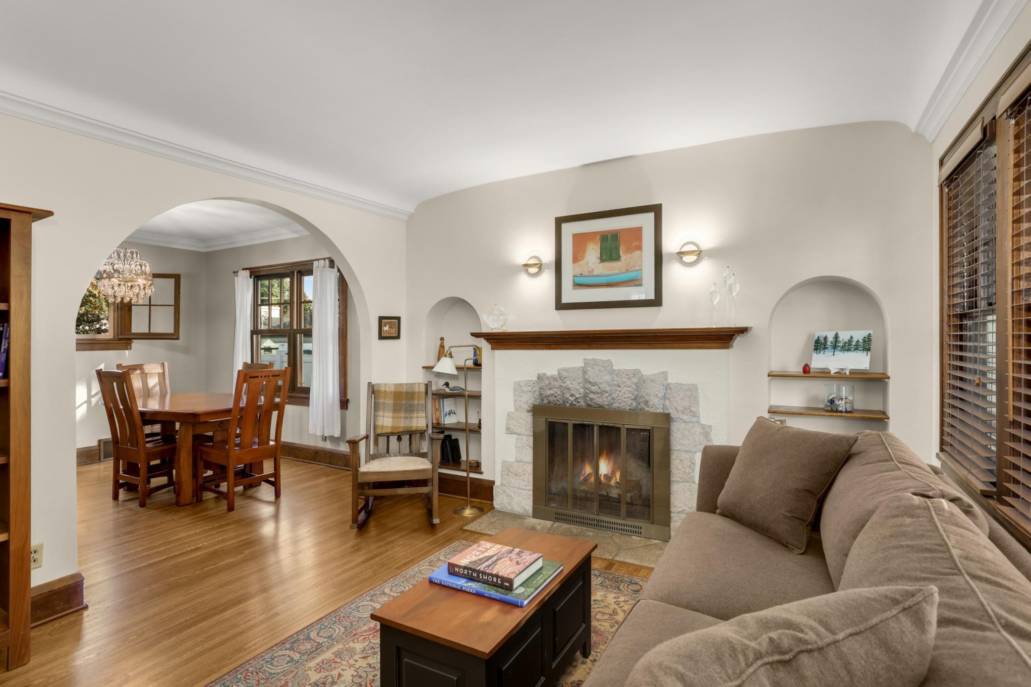 The living room features classic archways, gorgeous woodwork, and a stunning fireplace framed by arched bookshelves