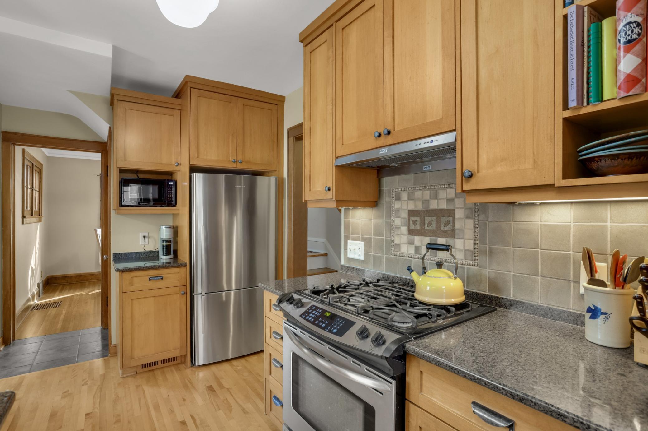 The beautifully updated kitchen is a true highlight of this gorgeous home, including custom cabinetry, stainless appliances, and tile
