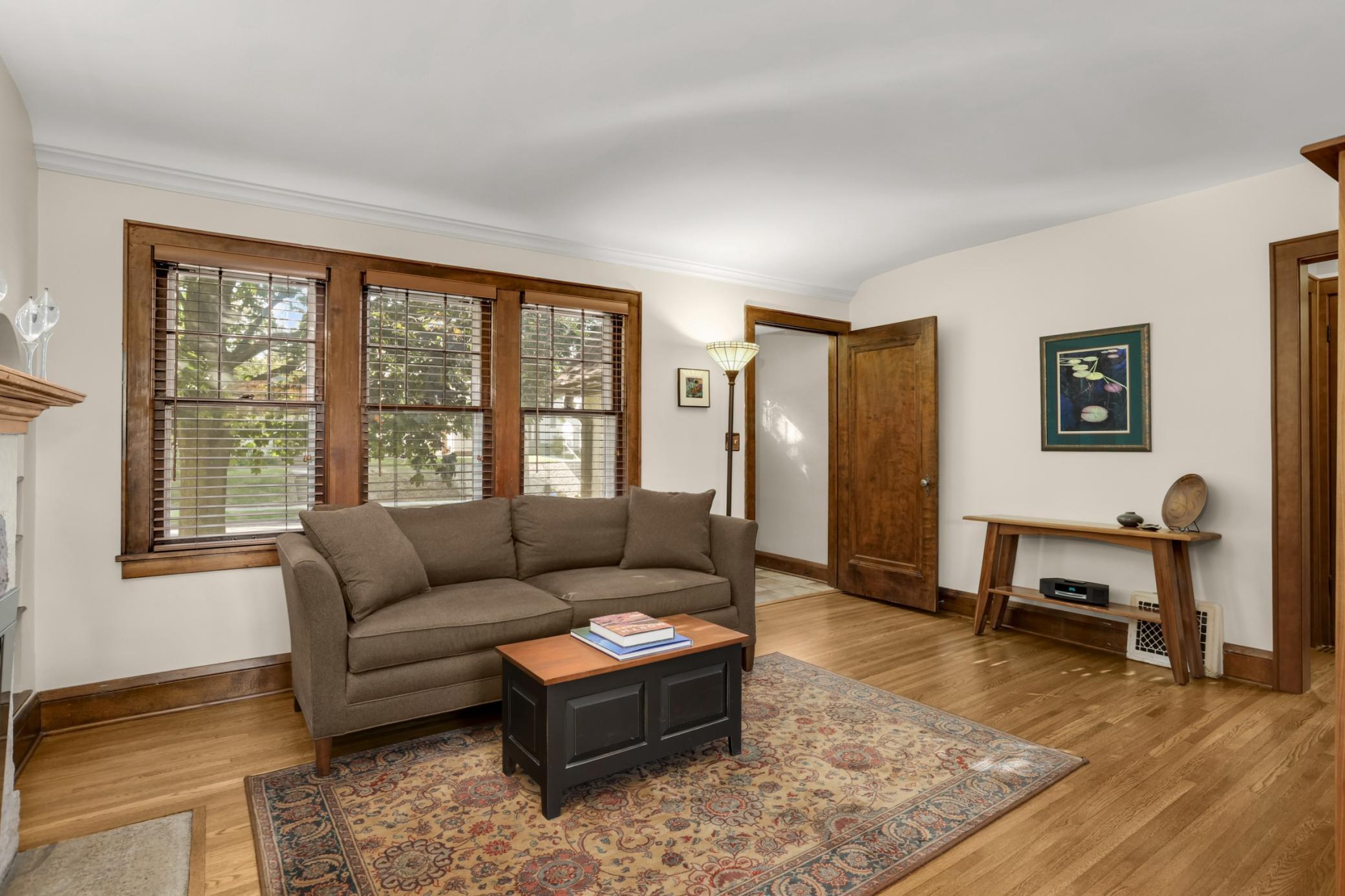 The spacious living room has beautiful woodwork and windows