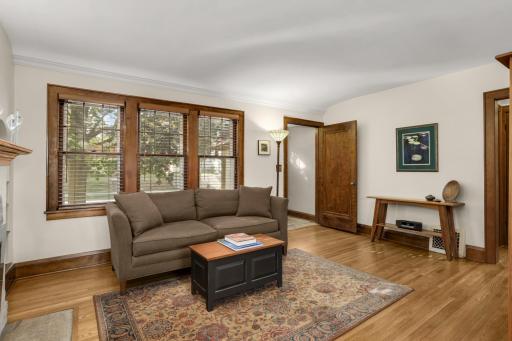 The spacious living room has beautiful woodwork and windows