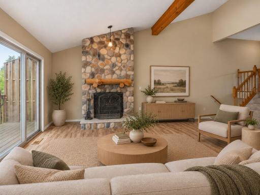 The stunning floor to ceiling wood burning fireplace anchors the living room - virtually staged