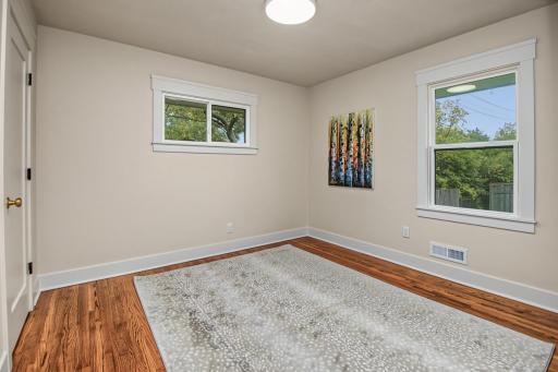 Secondary main level bedroom with hardwood floors.