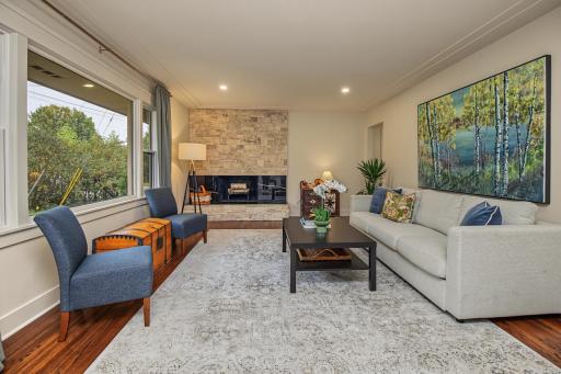 Very spacious living room with hardwood floors and refurbished wood burning fireplace.
