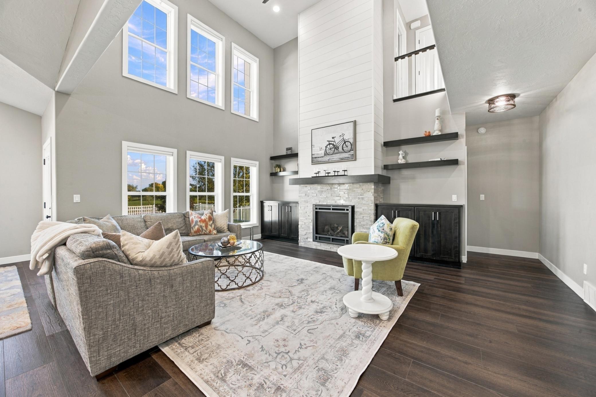 Living Room featuring double height ceiling, LVP Flooring, gas fireplace and built in cabinets