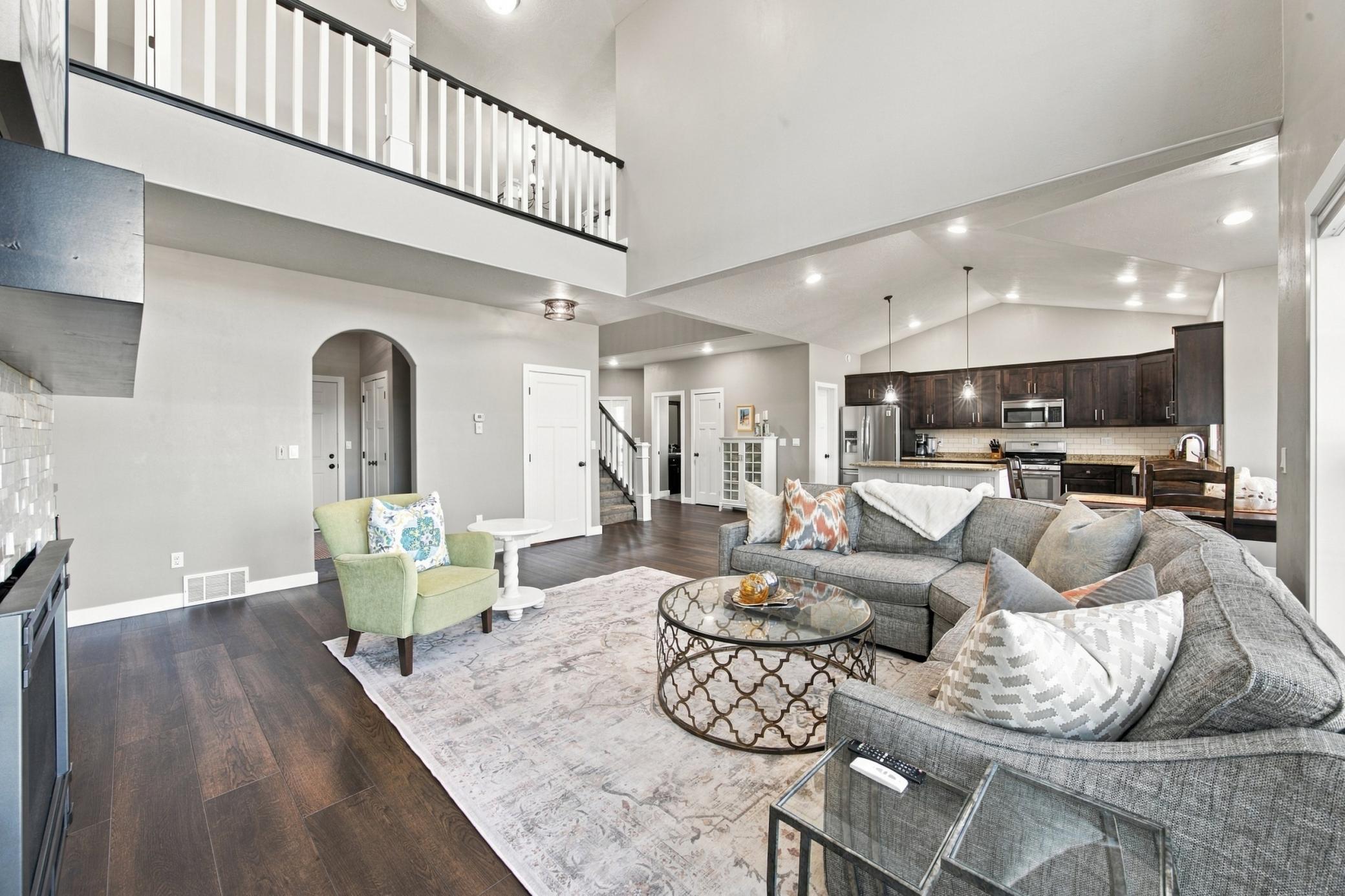 Open Concept Living with LVP Flooring, vaulted ceilings in the kitchen, and double height ceiling in living room.