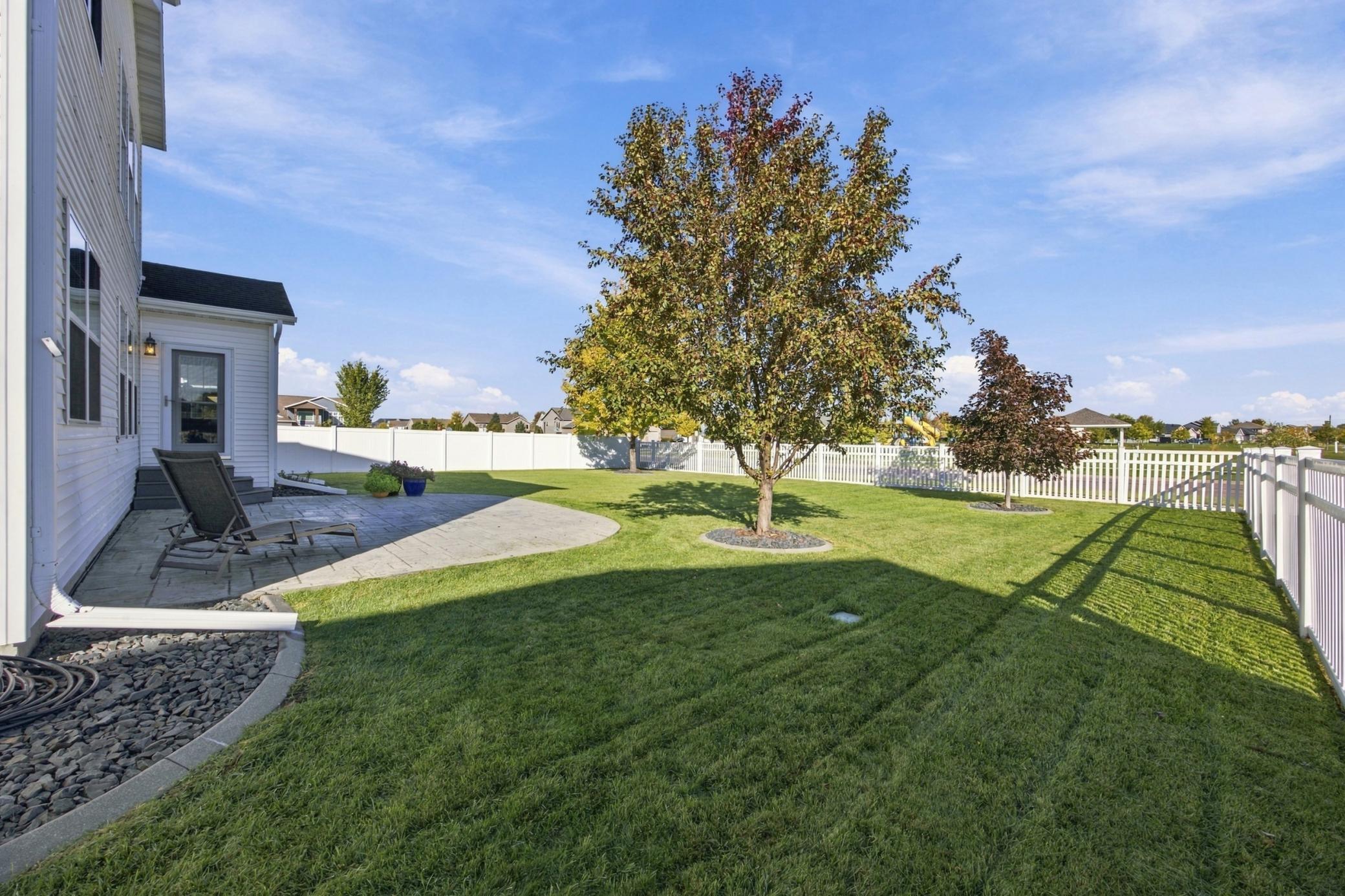 Backyard is fully fenced and features curbed landscaping and a stamped concrete patio