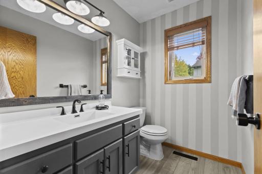 The main level features a convenient half bath, with ceramic tile plank flooring.