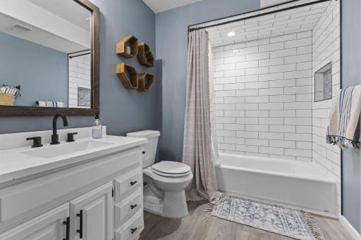 This modern full bathroom features an amazing shower with tile surround and toiletry niche.