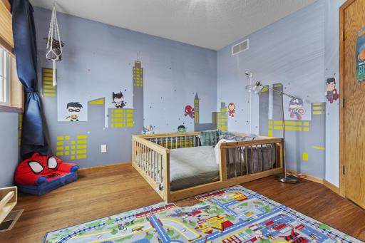 The second upstairs bedroom features a fun cityscape wall design.