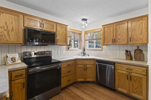 The kitchen features stainless steel appliances, custom backsplash, and updated light fixtures which carry through the whole home.