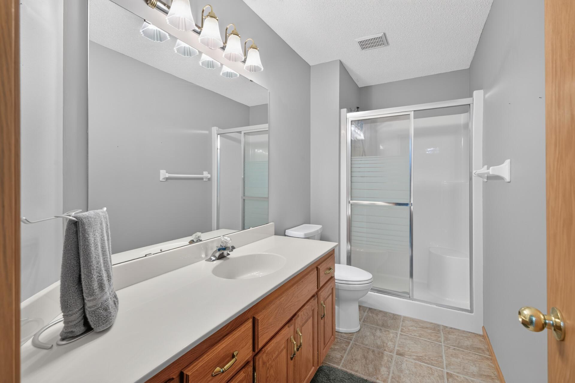 Spacious 3/4 bathroom in the basement with a ceramic tiled floor.
