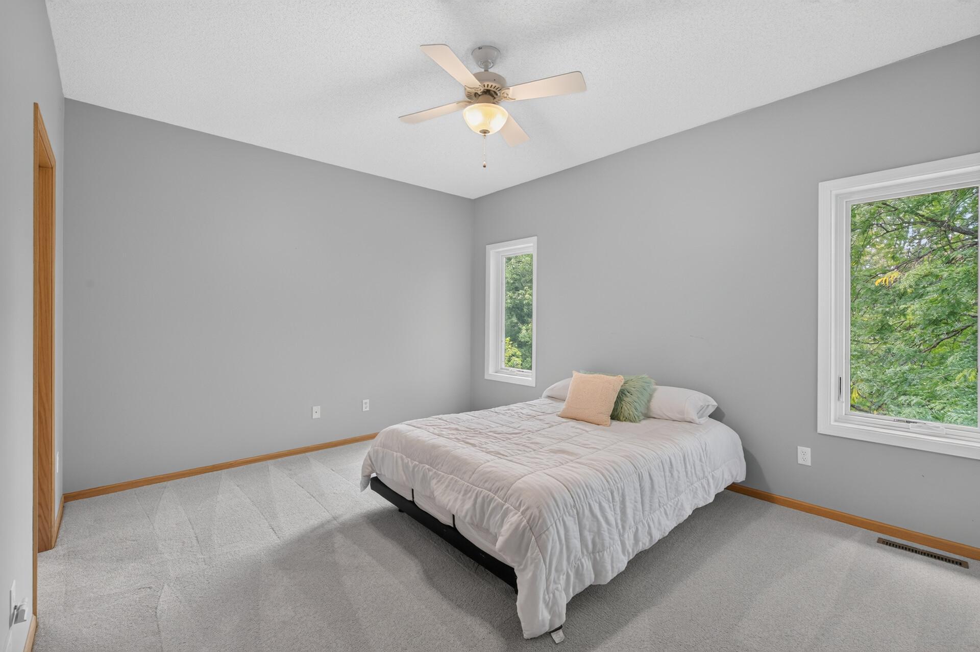 Nice sized primary bedroom with split casement windows, a ceiling fan and a great view of the private backyard.
