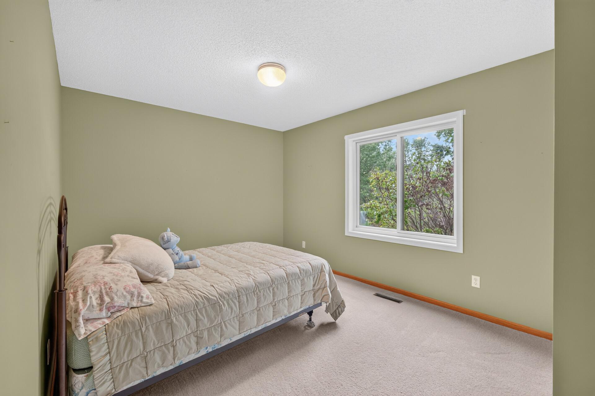 Bedroom # 3 in the basement with a view of the wildlife and treed backyard.