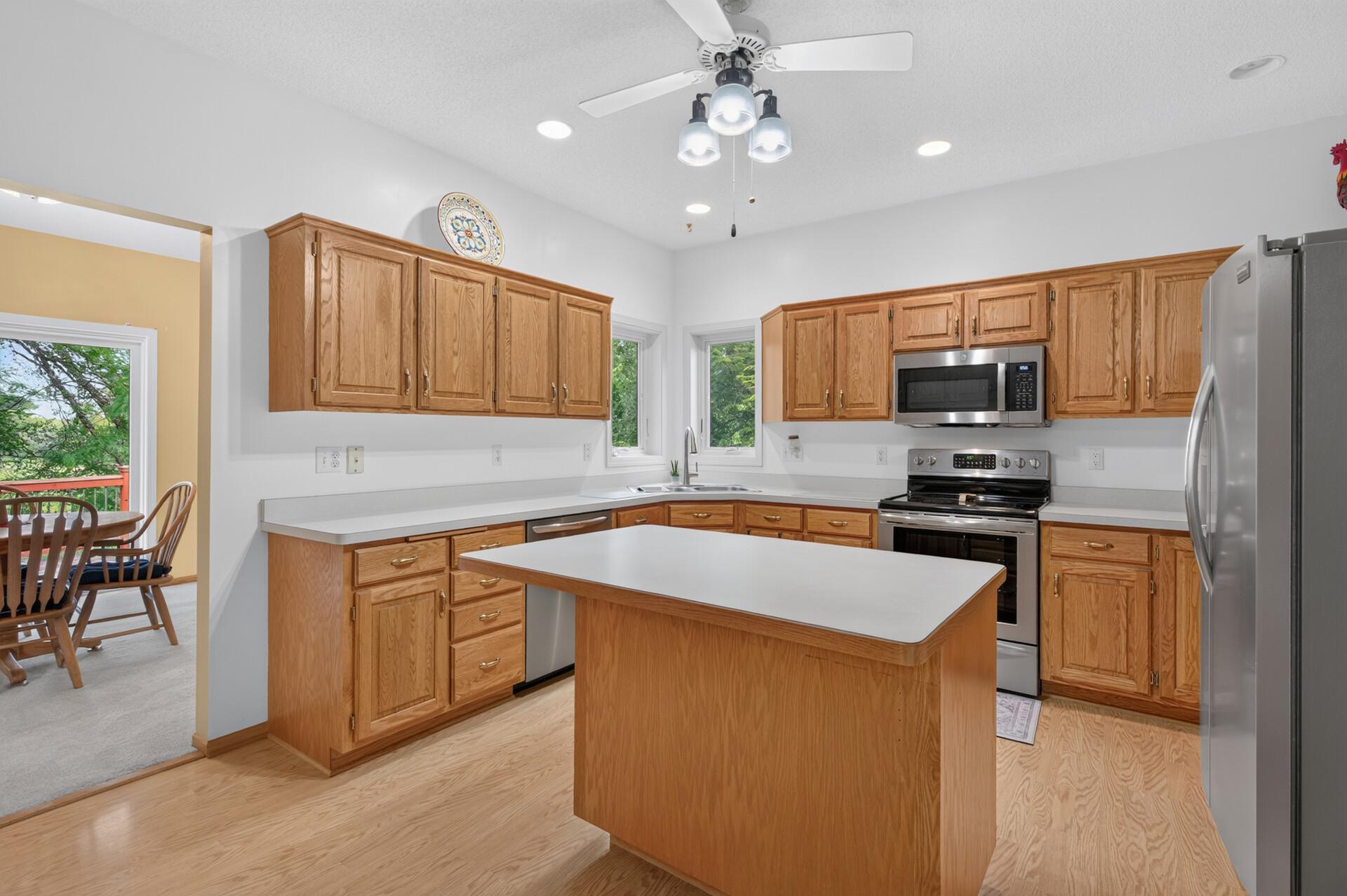 Lots of custom built oak cabinets, center island with snack bar overhang and stainless steel appliances.
